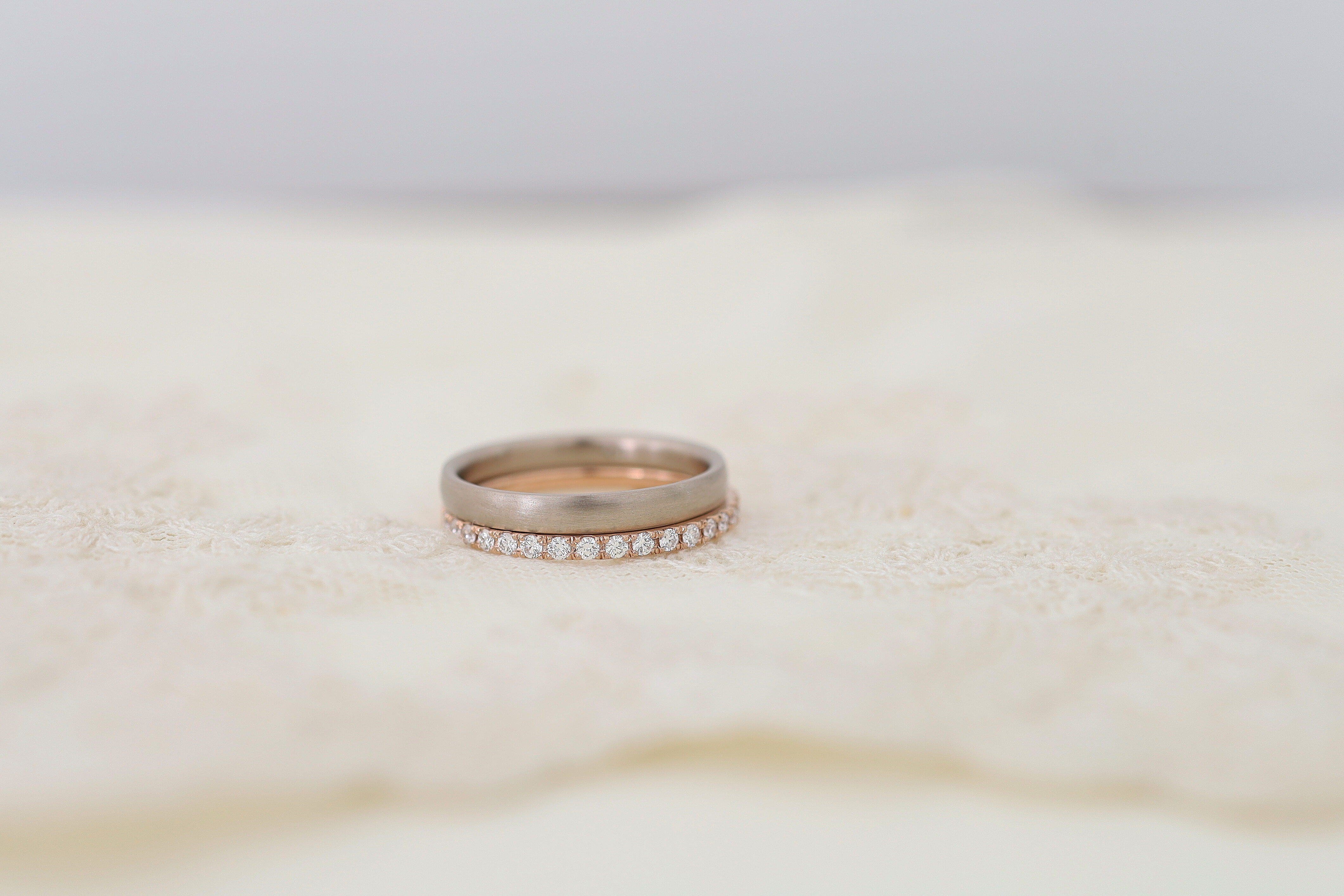 シンプルな結婚指輪と、ピンクゴールドのエタニティリングの重ね付け