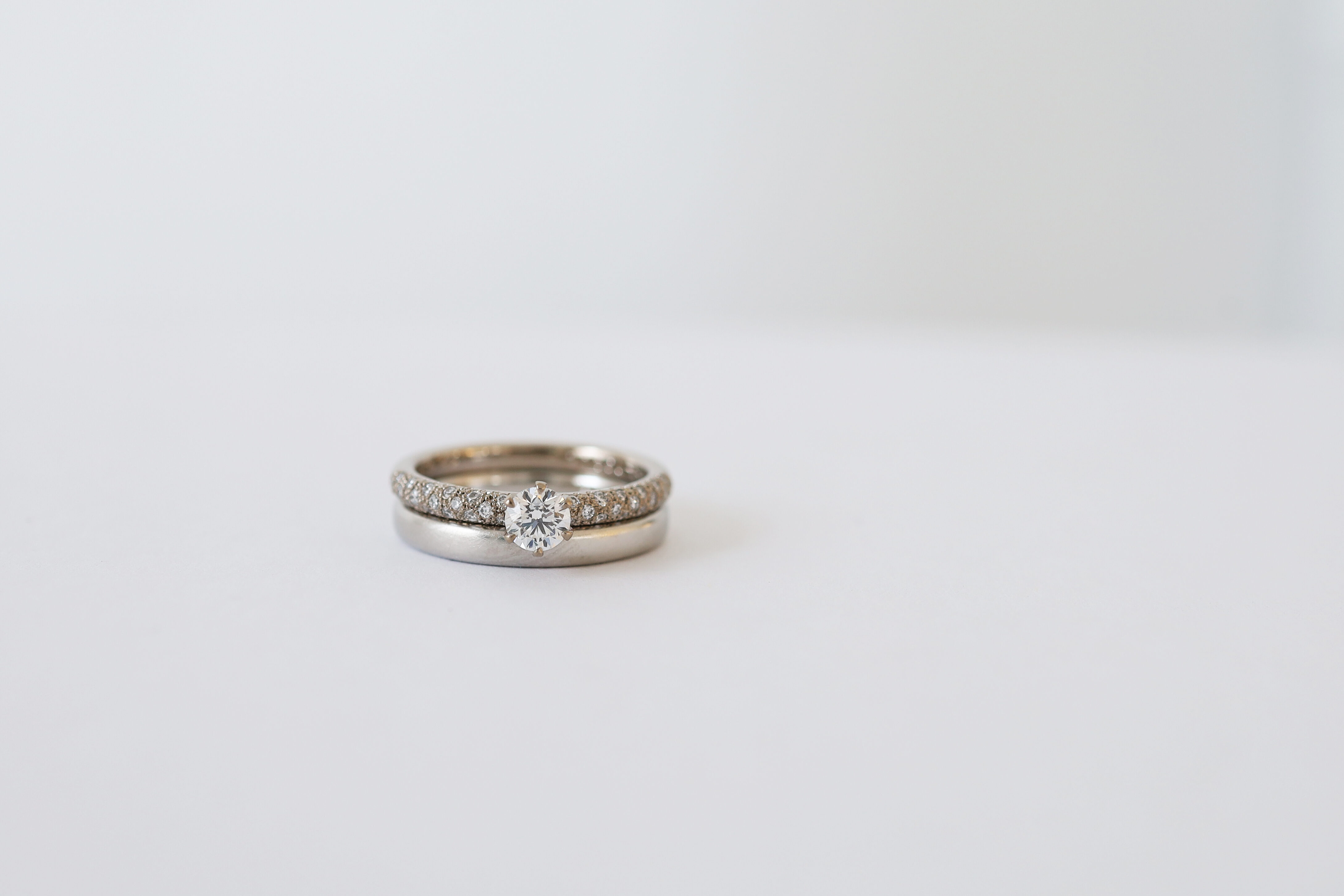 K18ホワイトゴールドのパヴェの婚約指輪と、プラチナのシンプルな結婚指輪の重ね付け