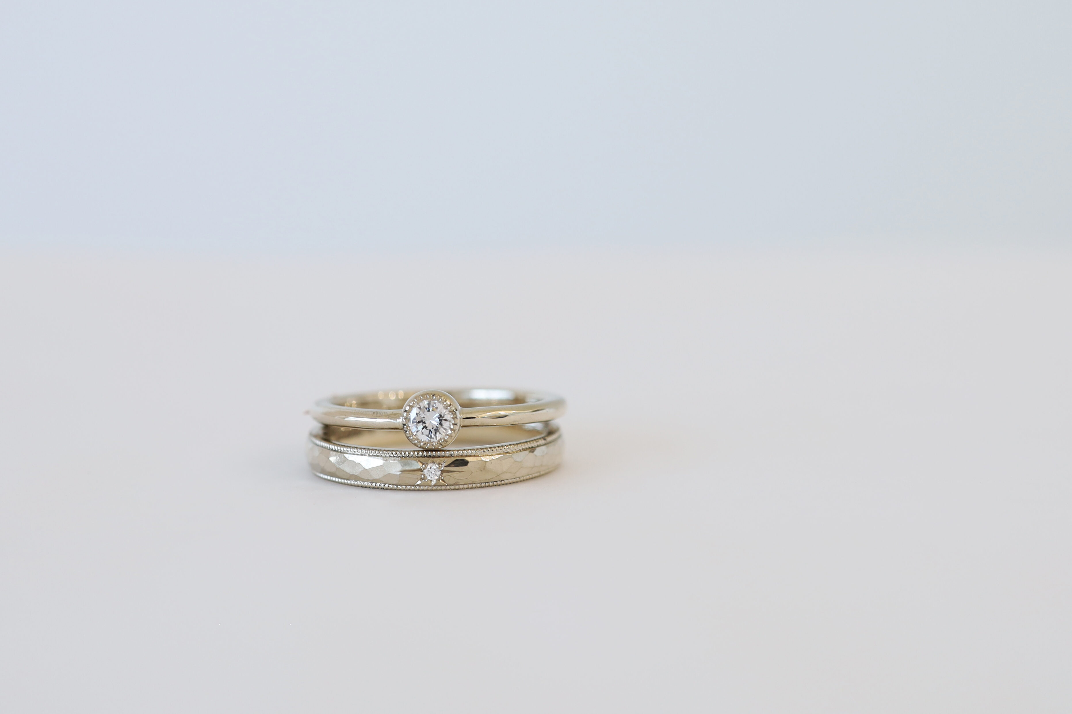 K18シャンパンゴールドのふくりん枠婚約指輪と、ミルグレインの結婚指輪の重ね付け