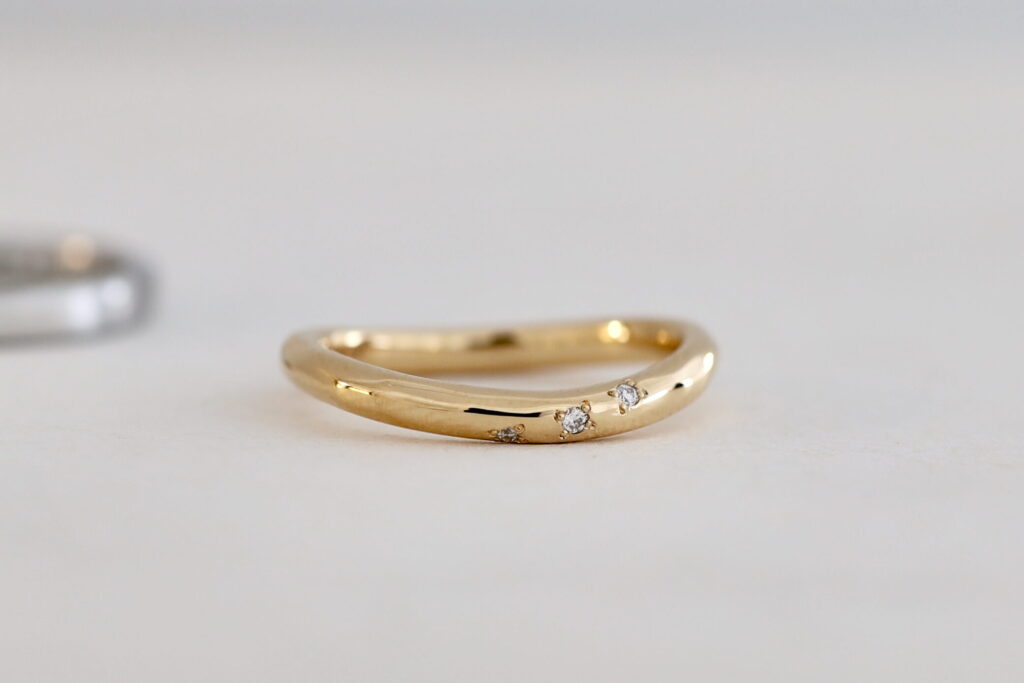 関西のオーダーメイドの結婚指輪　ウェーブのデザイン　艶があるK18イエローゴールド　斜めにダイヤモンドを留める