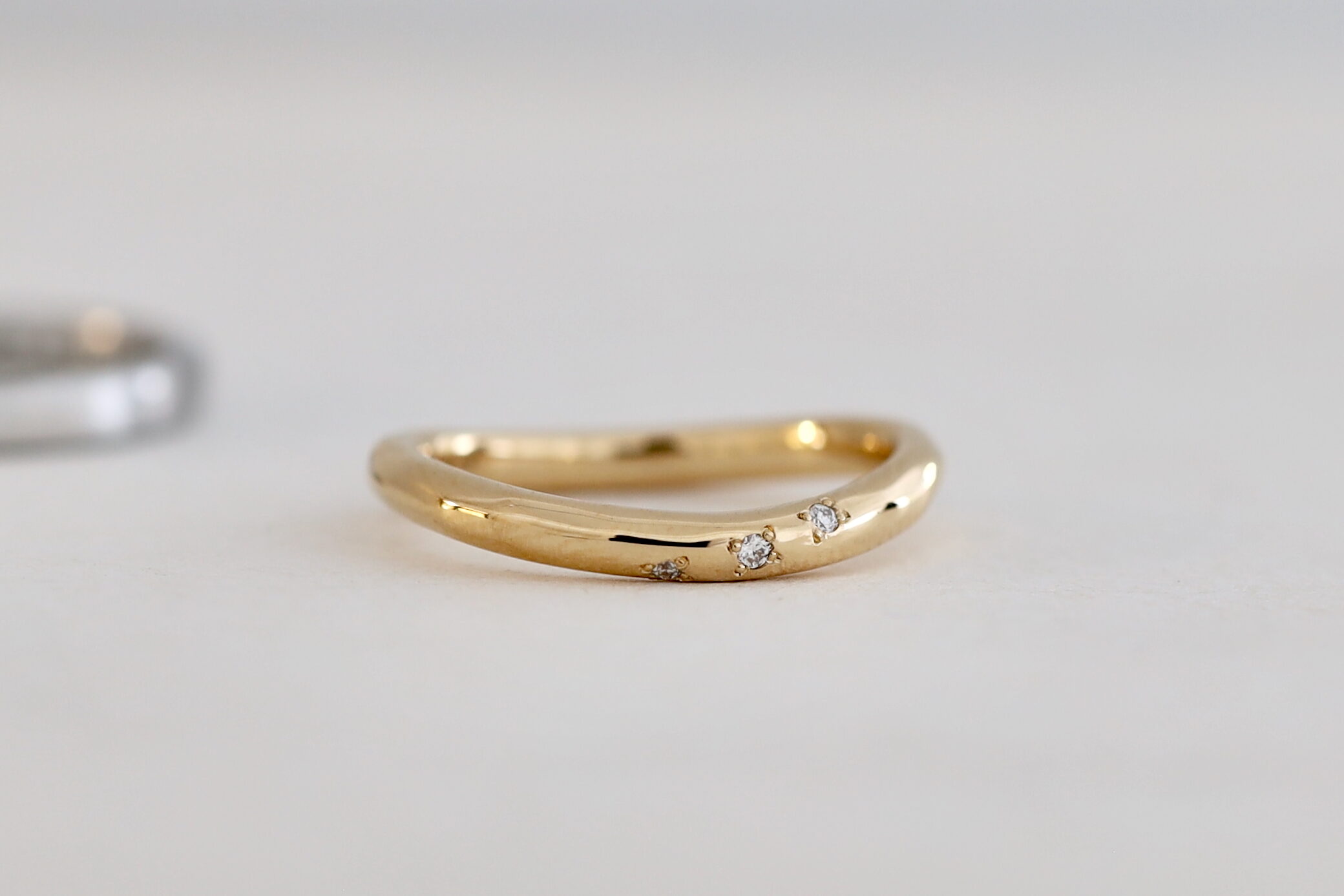 関西のオーダーメイドの結婚指輪 ウェーブのデザイン 艶があるK18イエローゴールド 斜めにダイヤモンドを留める