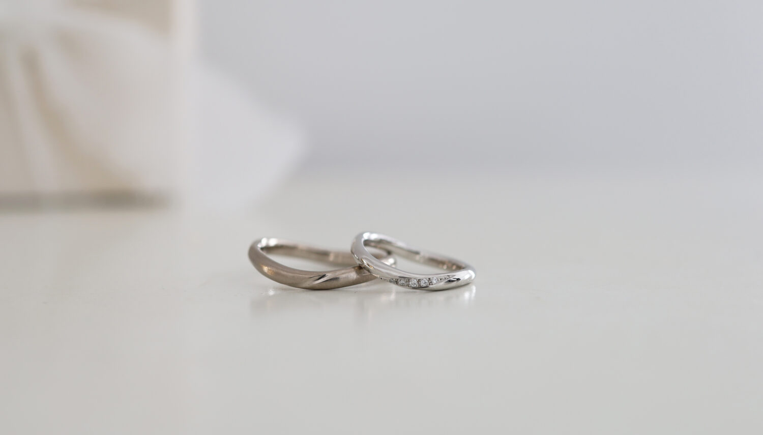 ウェーブした結婚指輪 K18ホワイトと Pt900 ひねり留めダイヤモンド