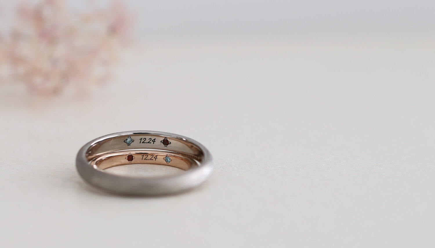 京都・大阪心斎橋のオーダーメイドリングのアトリエ"atelier tamari"おしゃれな結婚指輪のデザイン「リネン」の内側にアイスブルーダイヤモンドと1月の誕生石ガーネットを入れたグレーゴールドとピンクゴールド制作事例。結婚指輪の内側に石を２石留めた珍しいデザイン　