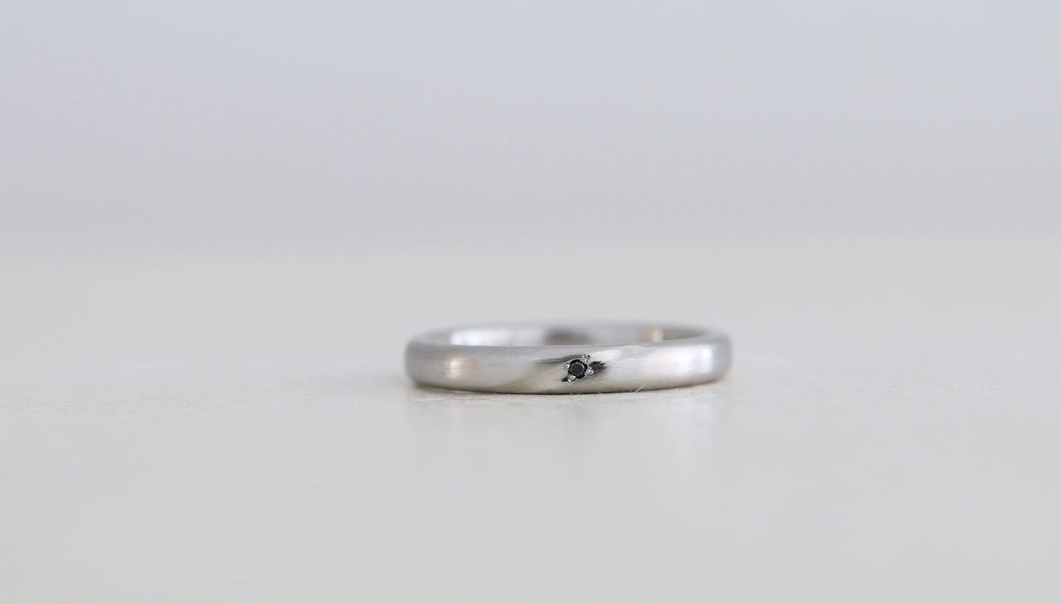 プラチナにブラックダイヤを留めた結婚指輪　ななめに彫りを入れた事例