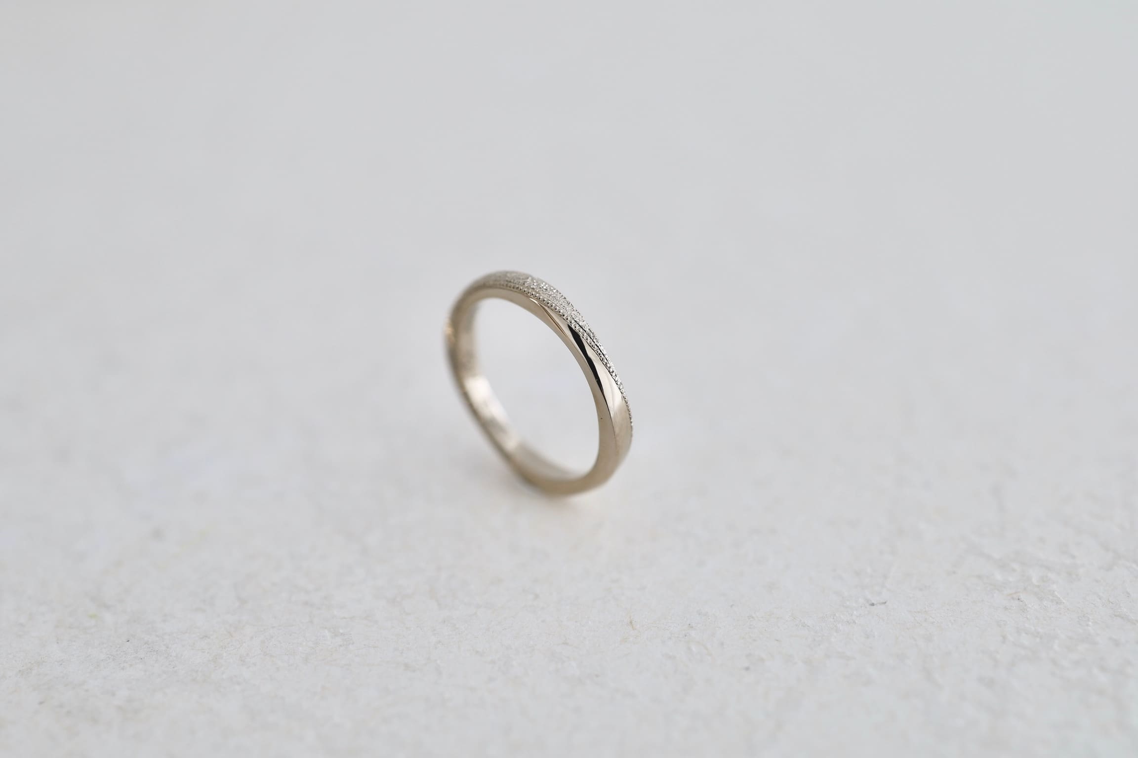 ダイヤモンドダスト加工と繊細なミルグレインが輝くツイストの結婚指輪　シャンパンゴールド