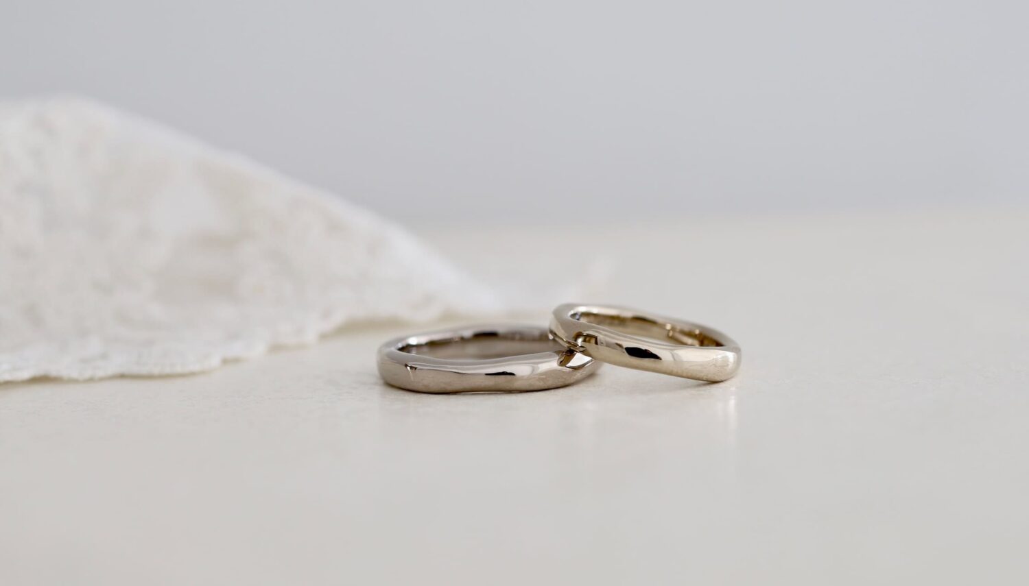K18ホワイトゴールドとK18シャンパンゴールドの結婚指輪「kumo（雲）」。手で叩いたような不均一な輪郭と、ぽってり厚みのあるフォルムが特徴の鏡面仕上げのペアリング。