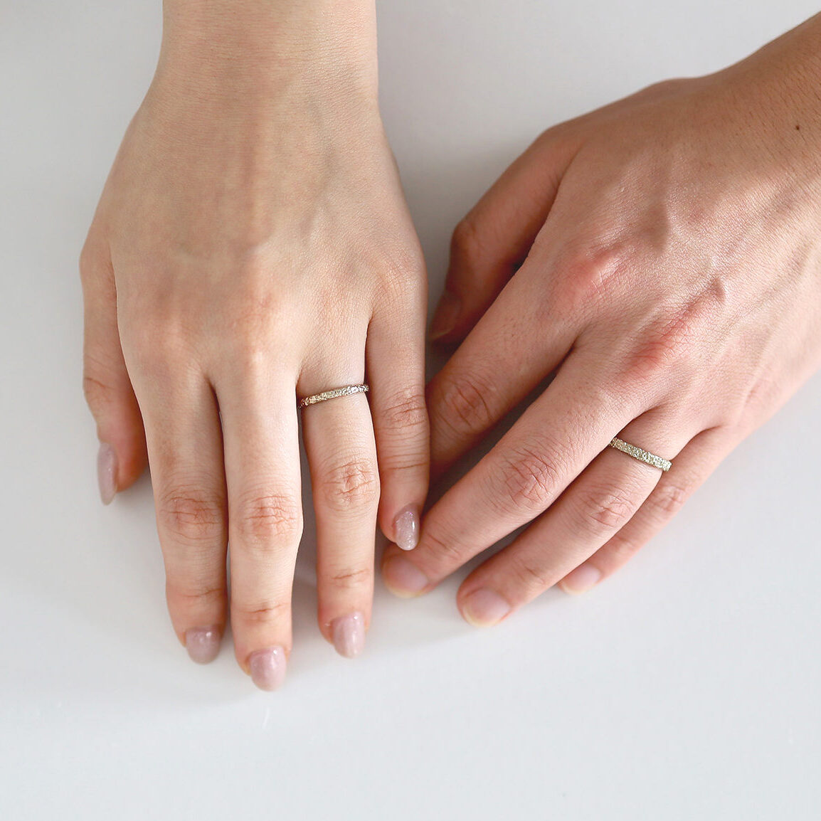 K18シャンパンゴールドで制作したmimosaの結婚指輪シャンパンゴールドを着用した男女の手元