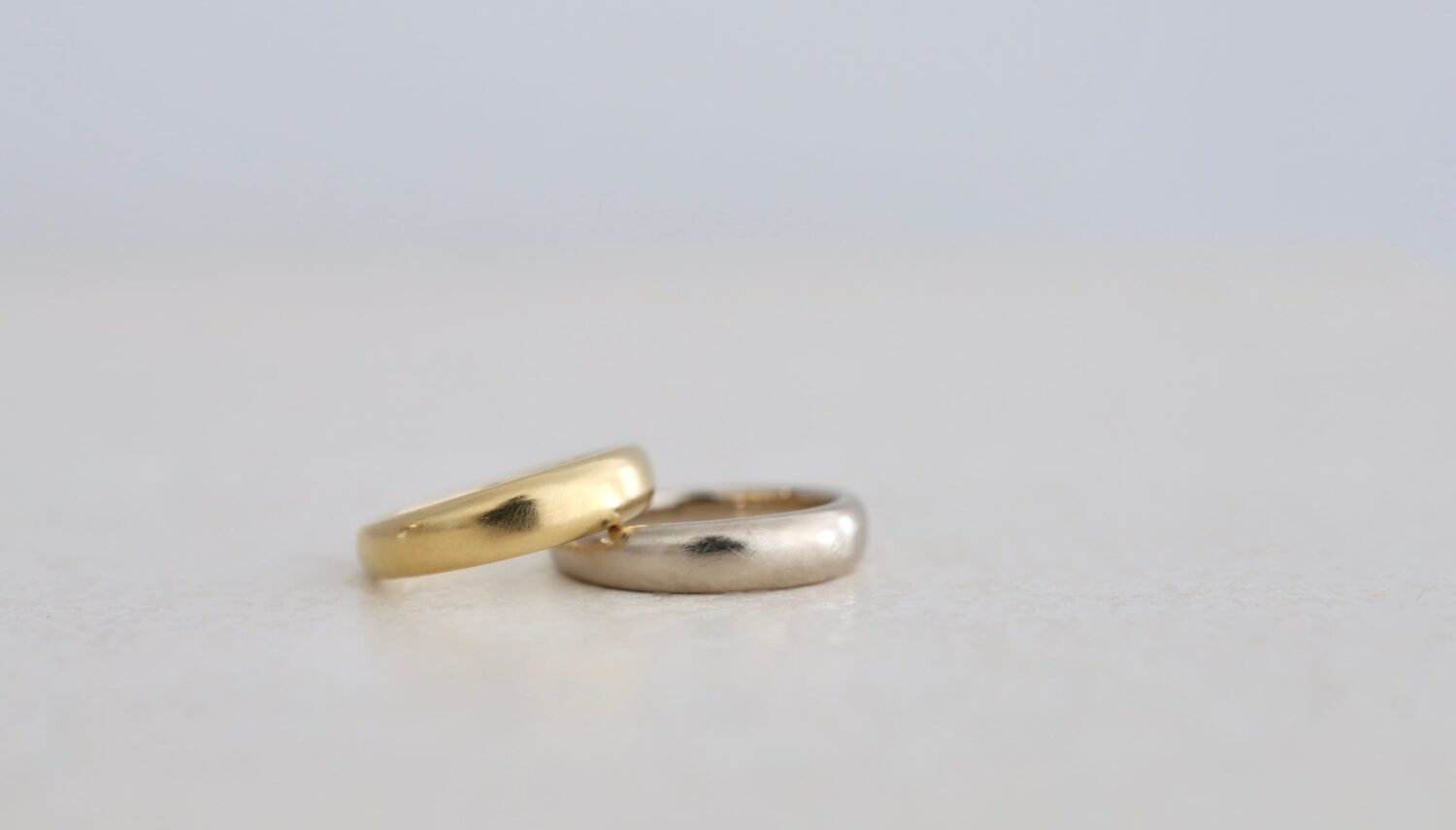 K18イエローゴールドとK18ホワイトゴールドの結婚指輪「wide oval（ワイドオーバル）」。幅広でふっくらと丸みのあるフォルムに、ブラシ仕上げを施したペアリング。