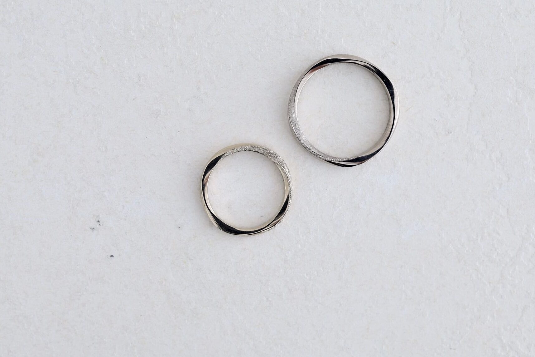 ゆるやかなひねりのある結婚指輪。ツイストのフォルムに表面加工を組み合わせたデザイン