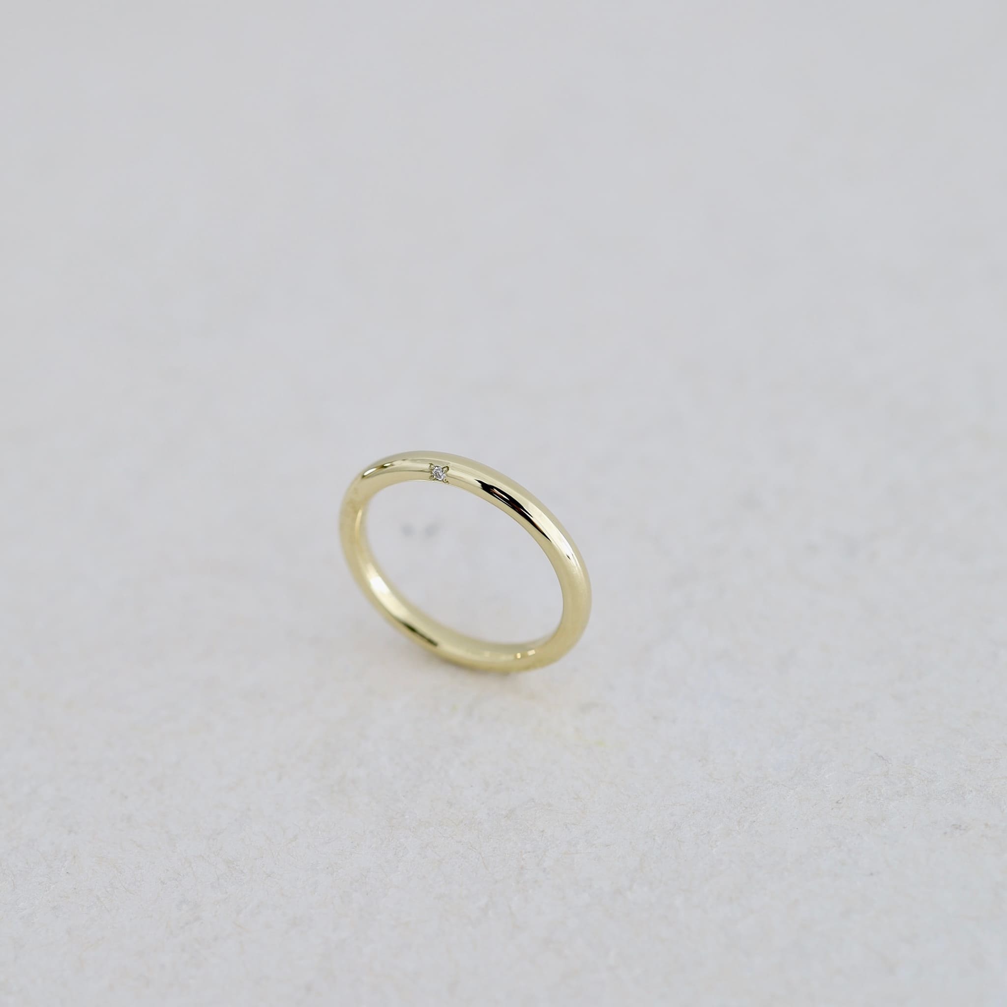 K18ライムゴールドの結婚指輪「donut」。厚みのある丸いフォルムの側面に一粒のダイヤモンドを留めたオーダー事例