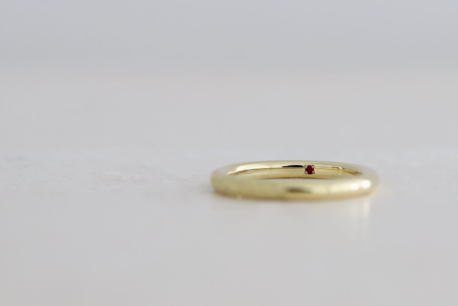 K18ライムゴールドの結婚指輪の内側に留めた真紅のルビー。オーダーメイドの内石アレンジ