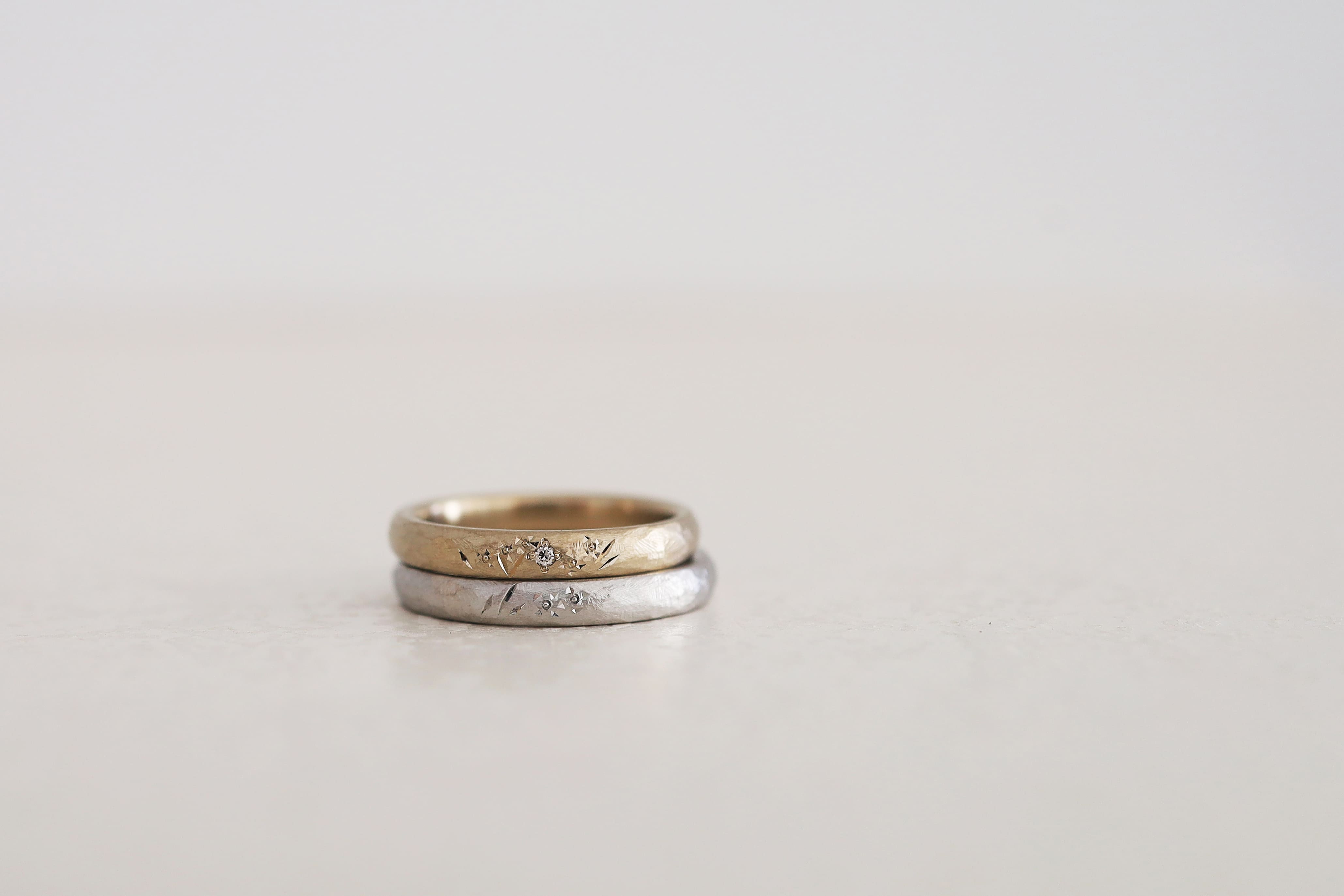 マット仕上げのアンティーク結婚指輪に手彫り模様を施した２本。片方にはブラウンダイヤモンドを留めたデザイン