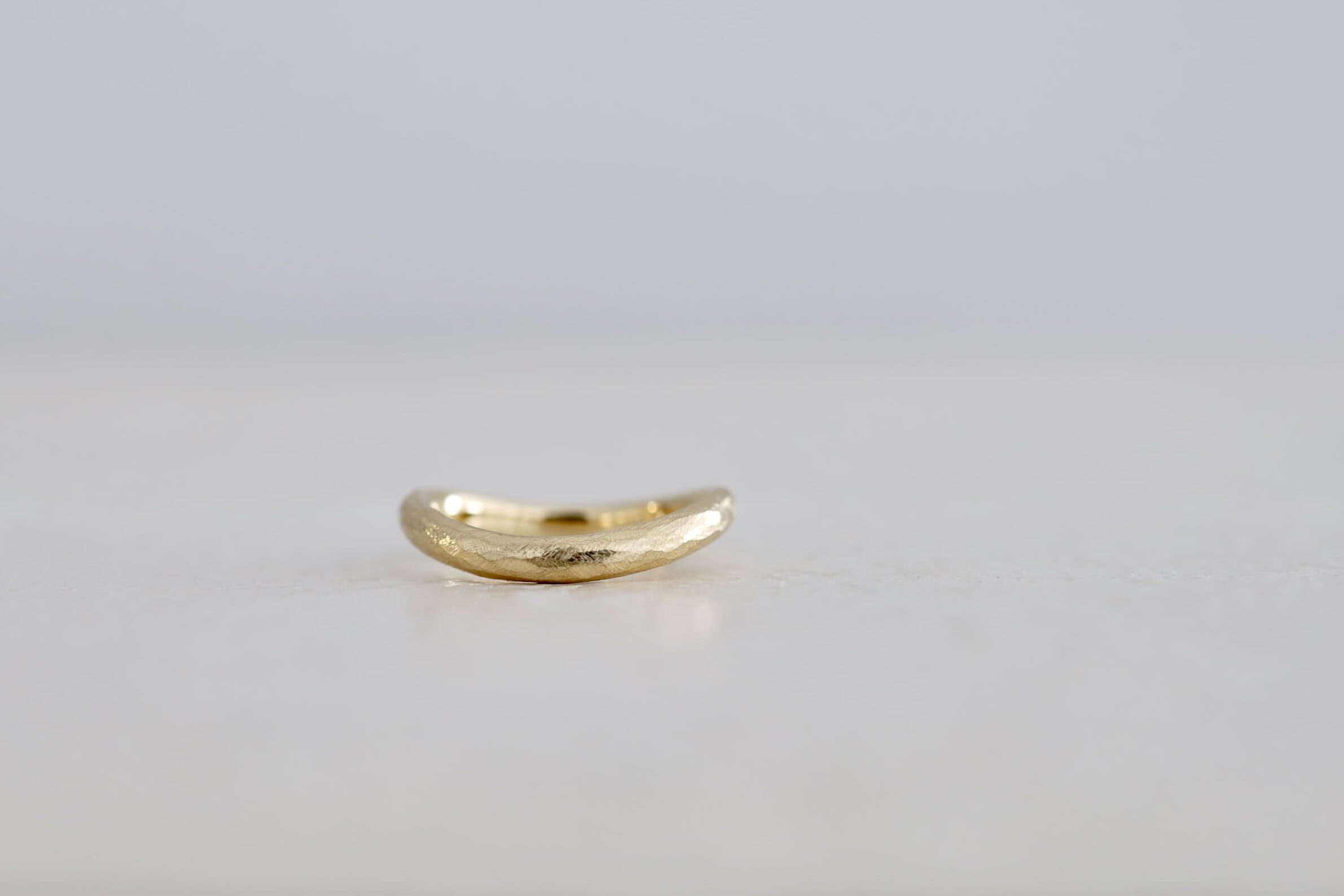 ゆるやかにカーブする結婚指輪「ウェーブ」に、ヤスリ目を残すアンティーク加工を施した制作事例